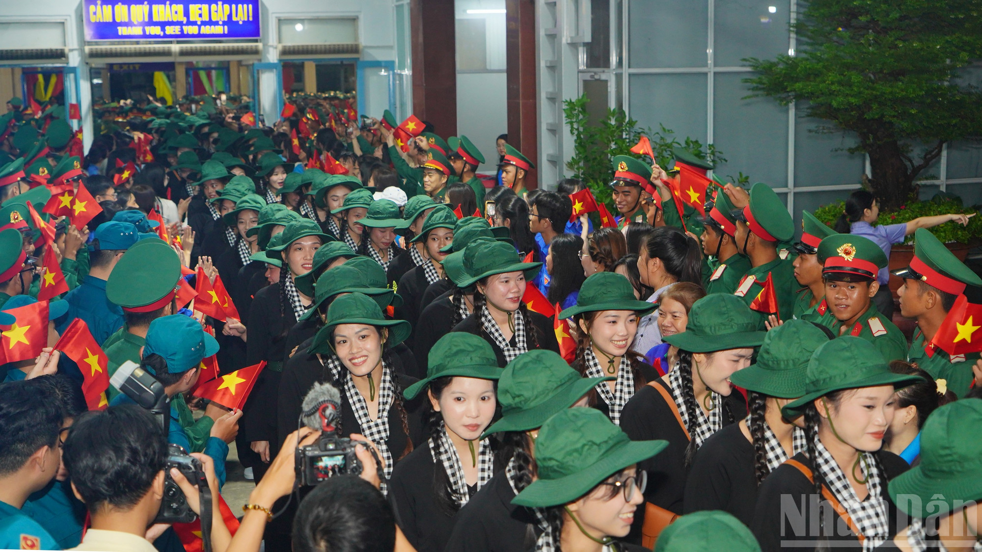 Dưới ánh đèn nhà ga, các nữ chiến sĩ chỉnh tề trong bộ quân phục, ôm chầm lấy người thân trước giờ xuất phát. ndo_br_24.jpg
