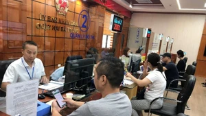 Cán bộ bộ phận Một cửa quận Hai Bà Trưng (Hà Nội) giải quyết thủ tục hành chính cho người dân. (Ảnh: BÍCH NGỌC) 
