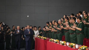 Các đại biểu chào mừng Tổng Bí thư Tô Lâm cùng các đồng chí lãnh đạo Đảng, Nhà nước dự chương trình giao lưu nghệ thuật "Khắc ghi lời Bác - vang nhịp quân hành". (Ảnh: SƠN TÙNG)