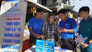 Đoàn viên hướng dẫn tiểu thương thanh toán không dùng tiền mặt tại chợ Mỹ Ngãi, Phường 1, thành phố Cao Lãnh.